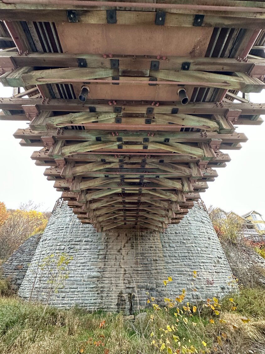 From below the Roebling Bridge, the Canal Towpath Trail provides a closer view of the massive trusses and cables.